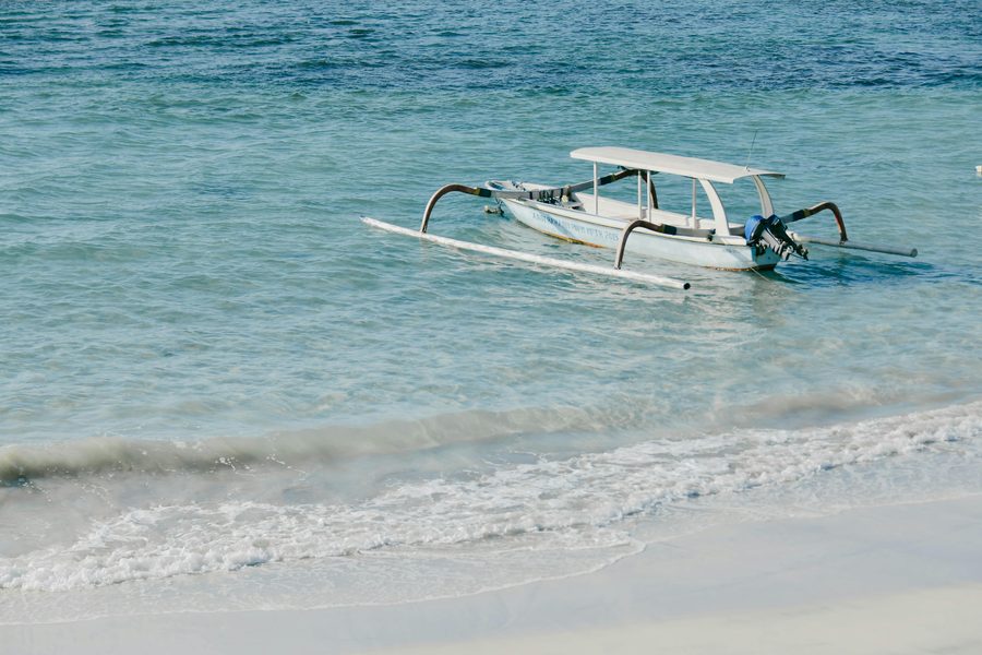 Traditional Bali outrigger fishing boat on turquoise shallows