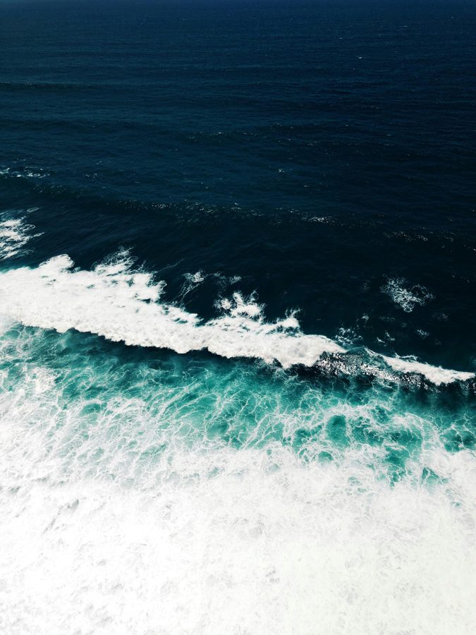 Deep blue Bali ocean surf break from above