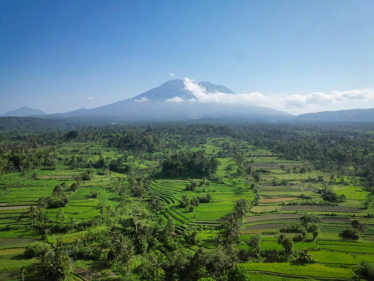 Mount Agung under clear blue sky with lush green rice terraces — Bali dry season (May–October)